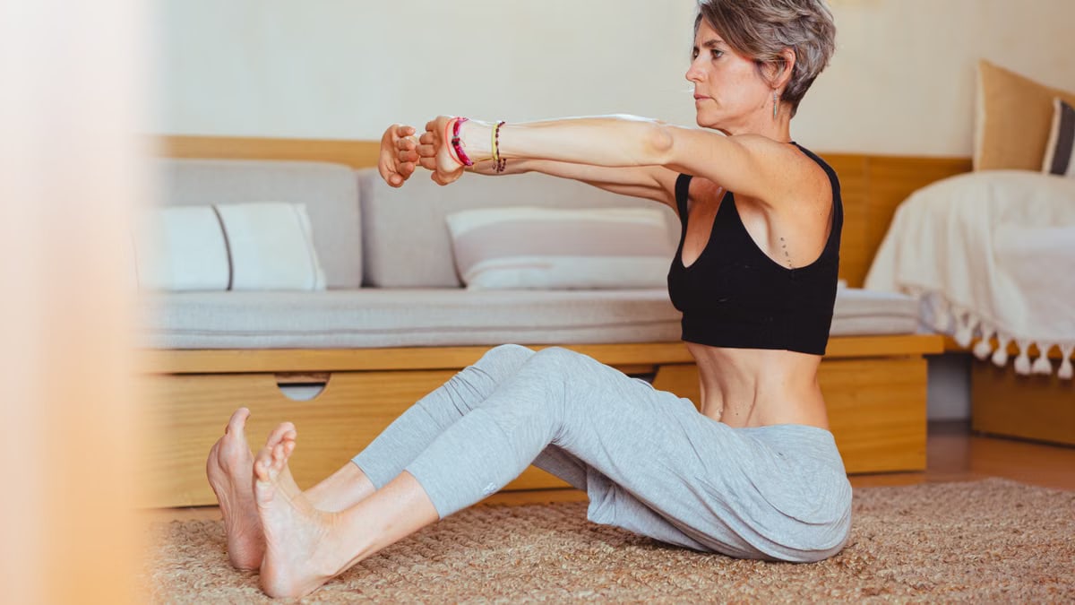 Elderly woman in a yoga pose indoors, embracing healthy lifestyle and wellness.